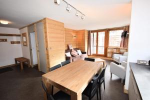salon z drewnianym stołem i krzesłami w obiekcie Résidence Le Mont Blanc - 3 Pièces pour 6 Personnes 024 w Aime La Plagne
