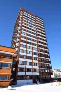 wysoki budynek na śniegu z ludźmi stojącymi przed nim w obiekcie Résidence Le Mont Blanc - 3 Pièces pour 6 Personnes 024 w Aime La Plagne +5 zdjęć