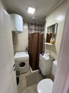 mała łazienka z umywalką i pralką w obiekcie Apartment studio 30 w Sarajewie