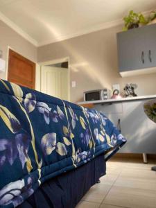 a blue couch sitting in a living room at SummerPlace Studio Apartments with Kitchenette in Modimolle +10 photos
