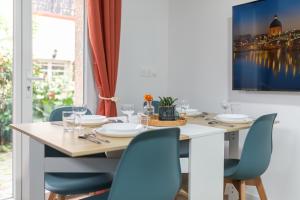 a dining room with a table and blue chairs at Douceur d'argile in Toulouse +28 photos