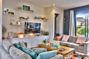 a living room with two couches and a tv at Magnifique demeure à 15 min des plages 12 adultes in Saint-Renan