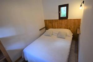 Un dormitorio pequeño con una cama blanca y una ventana. en Chalet Schi Jaacas - Chalet SCHI JAACAS - 8/10 pers - PLAGNE CENTRE MAE-8424, en Aime La Plagne 3 fotos más
