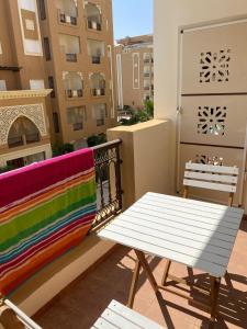 a bench and a table on a balcony at Bel appartement dans une résidence à Folla Aqua Resort Chat Meriem in Sousse