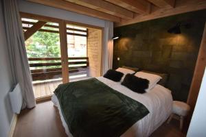 Un dormitorio con una cama grande y una ventana. en Résidence Alpine Loft - 5 Pièces 10 pers- HAUT DE GAMME - ALPINE LOFT - 10ALPI - PLAGNE CENTRE MAE-2634, en Aime La Plagne