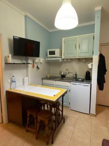 a kitchen with a table and a counter top at Relógio Home in Figueira da Foz