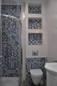 a bathroom with blue and white tiles on the wall at Peti's Apartment in Prinos +10 photos