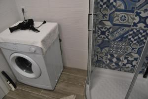a washing machine in a bathroom with a shower at Peti's Apartment in Prinos