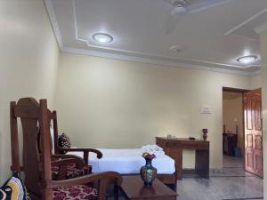 a bedroom with a bed and a table and chairs at Jan Mahal in Srinagar
