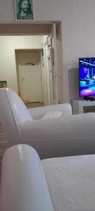 a hospital room with white chairs and a tv at Caen la mer in Caen