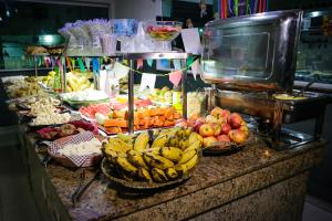 a fruit stand with bananas and other fruits on a counter at Hotel San Rafain in Aparecida