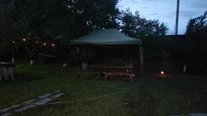 een picknicktafel onder een tent in een tuin 's nachts bij Giarants in Sagmosavan +2 foto's
