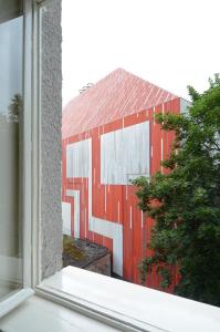 a view of a red building from a window at Extraordinary quiet apartment in the very centre in Bratislava