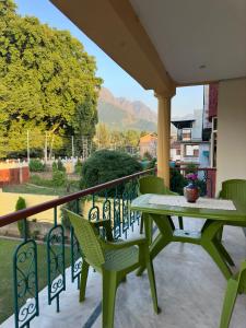 a green table and chairs on a balcony at Jan Mahal in Srinagar
