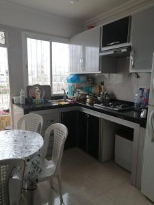 シディ・ラハルにあるAppartement Diar châtie Sidi Rehalのキッチン(テーブル、椅子、テーブル、テーブル付)、