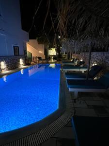 a large swimming pool at night with lights at Santa Magia in Kamari