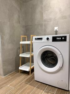 een wasmachine in een kamer met een plank bij SK Apartment in Neoi Epivatai