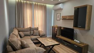 a living room with a couch and a flat screen tv at Tirana Airport Apartment in Tirana