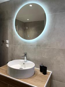 a bathroom with a sink and a round mirror at SK Apartment in Neoi Epivates +15 photos