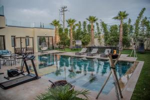a swimming pool in a yard with palm trees at AD Villa in Marrakesh