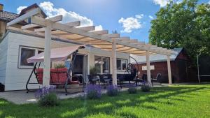 pergola na patio z krzesłami pod nim w obiekcie Apartament Domek Romi w Augustowie do wynajęcia w mieście Augustów