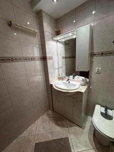 a bathroom with a sink and a toilet and a mirror at Apartament Gdynia Centrum in Gdynia