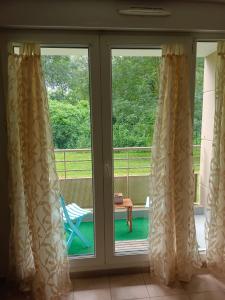 przesuwane szklane drzwi z widokiem na werandę w obiekcie Proche Disneyland Paris - Appartement avec balcon sans vis a vis - parking prive Résidence calme w mieście Montévrain