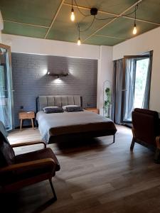 a bedroom with a large bed and a brick wall at Saules Club Apart Hotel in Saulkrasti
