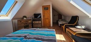 a attic bedroom with a bed and a desk and a tv at Keja in Łeba