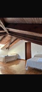 a bedroom with two beds and a wooden ceiling at Villa Natalia in La Zarzuela +9 photos