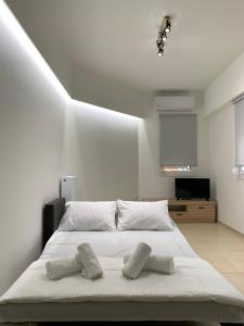 een slaapkamer met een wit bed met 2 kussens erop bij SK Apartment in Neoi Epivatai
