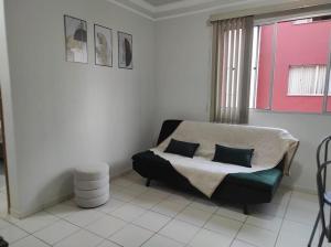 a living room with a couch and a window at Apto no Bairro Alto Umuarama in Uberlândia
