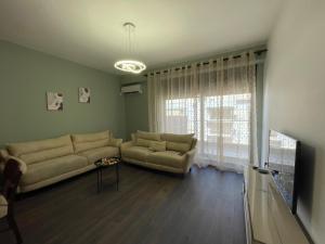 a living room with a couch and a window at JO-AL, Delijorgji in Tirana +3 photos