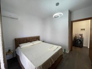 a bedroom with a large bed with white sheets at JO-AL, Delijorgji in Tirana