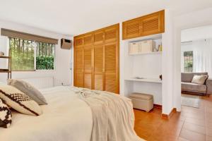 a bedroom with a large bed and a couch at Elviria Beachside House Marbella in Marbella