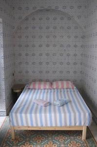突尼斯Belle maison dans la Médina的一间小卧室,配有一张带条纹床垫的床 更多8张照片