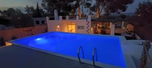 a blue swimming pool in front of a house at Ca la Yaya in Lliria