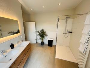 a bathroom with two sinks and a shower at COZY, neue 3 Zimmer Ferienwohnung Goslar Altstadt in Goslar +5 photos