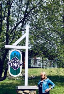 バルマウントにあるDream Catcher Innの看板の前に女性が立っている