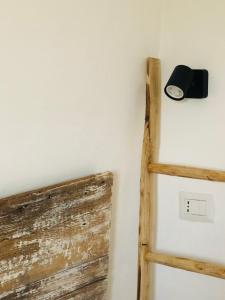 a clock on a wall next to a wooden ladder at Trullo dell'Upupa in Ostuni