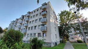 a tall white building with windows and a street light at Lovcik PRL in Głuchołazy