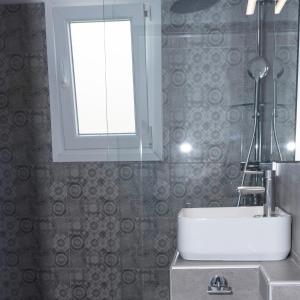 a bathroom with a sink and a window at Eleni's Seaview House in Andros +27 photos