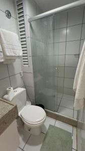 a bathroom with a toilet and a glass shower at Gran Solare Flat Residence - Mandacaru 505 in Barreirinhas