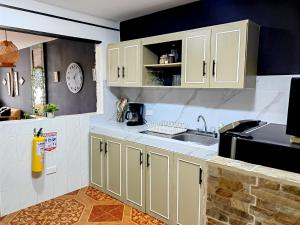 a kitchen with white cabinets and a sink at Acogedora casa céntrica in Salento