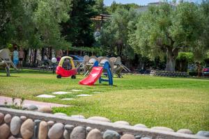 a park with a playground with slides and play equipment at Theramvos Superior Apartments in Hanioti