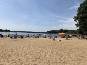 a group of people sitting on a beach at Apartamenty Trawers in Wielen Zaobrzanski +18 photos