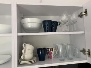a cupboard filled with glasses and plates and vases at Apartamenty Trawers in Wielen Zaobrzanski