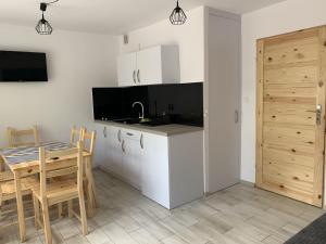 a kitchen and dining room with a table and a table and chairs at Apartamenty Trawers in Wielen Zaobrzanski