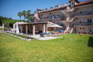a large building with a lawn in front of it at Theramvos Superior Apartments in Hanioti