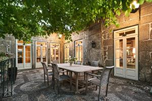 a wooden table and chairs in front of a building at Solar de Vilar Seco in Vilar Seco
